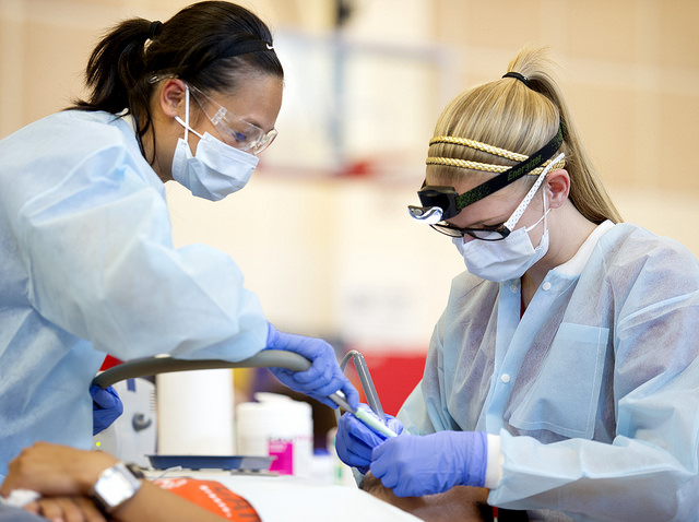Dental hygiene students Tammy Ngo, left, and Cassidy Robinson work with a patient.
