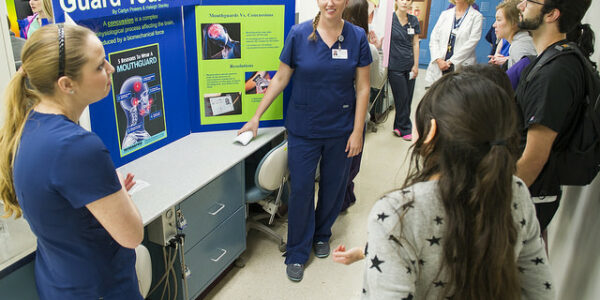 Students and faculty gather to listen to dental hygiene table clinics during Research Scholars Day at TAMBCD.