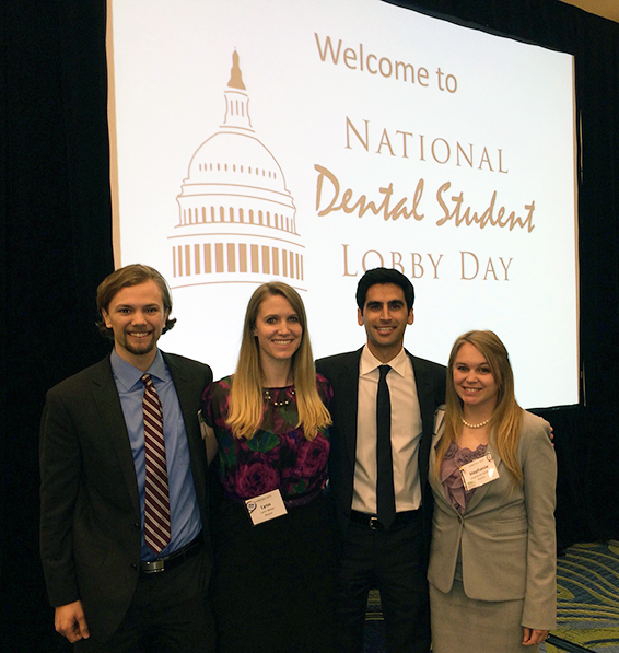 TAMBCD attendees in front of a sign depicting National Dental Student Lobby Day