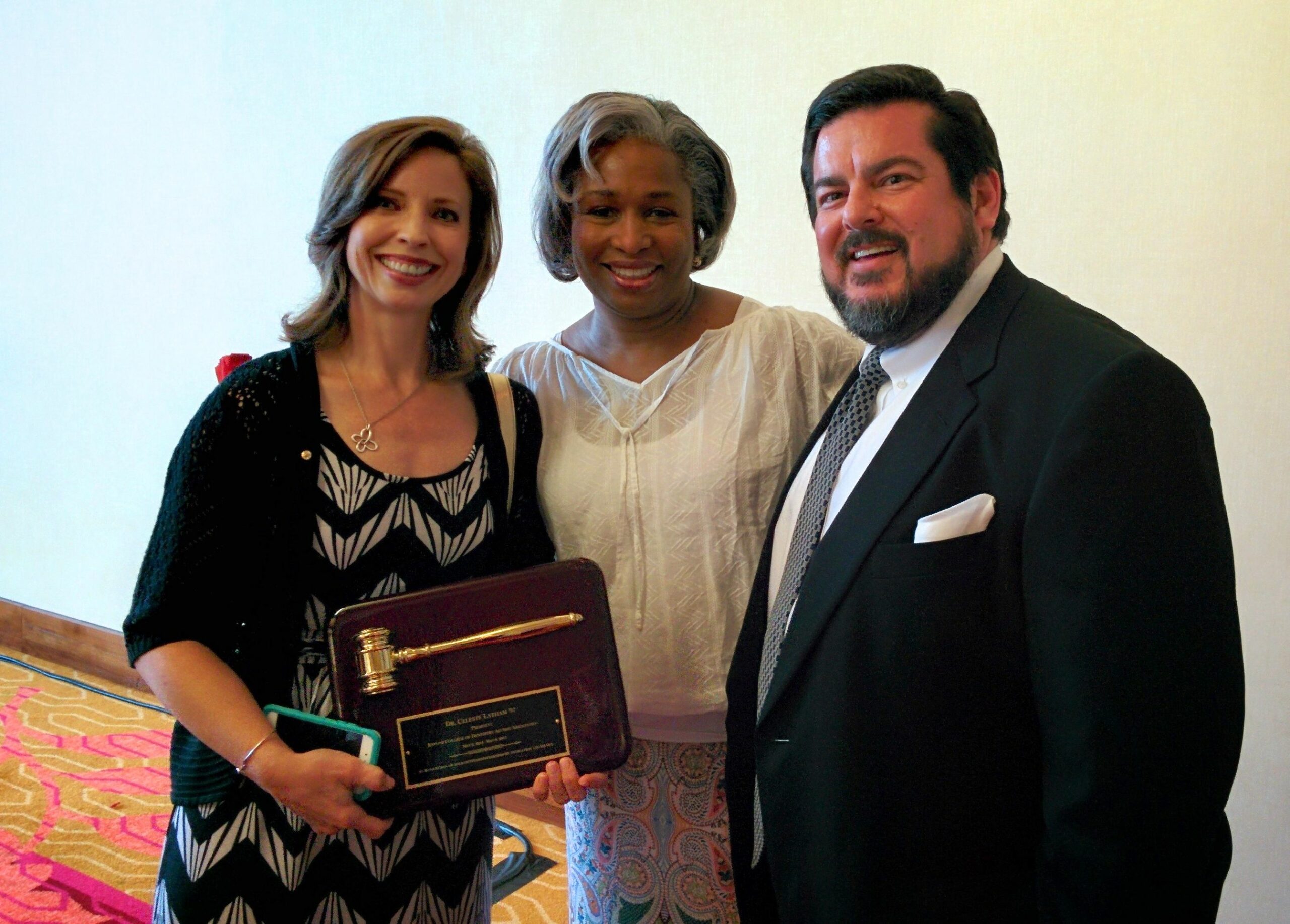 Alumni past-president Dr. Celeste Latham passes the gavel to new president Dr. Lee Kavanagh