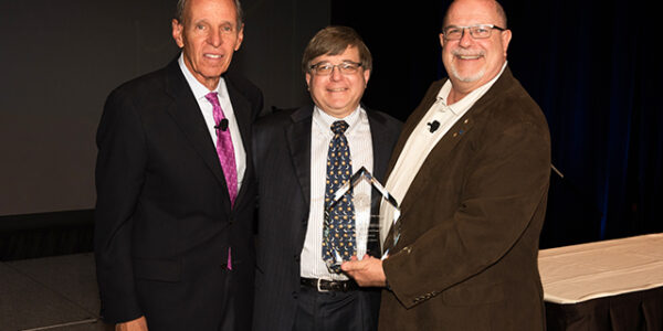 AAE Honors and Awards Chairman Dr. Shepard Goldstein, left, and President Dr. Robert Roda, right, present Dr. Jordan Schweitzer with the Edward M. Osetek Educator Award at the AAE’s annual meeting in Seattle.