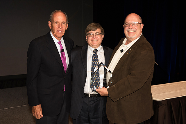 AAE Honors and Awards Chairman Dr. Shepard Goldstein, left, and President Dr. Robert Roda, right, present Dr. Jordan Schweitzer with the Edward M. Osetek Educator Award at the AAE’s annual meeting in Seattle.