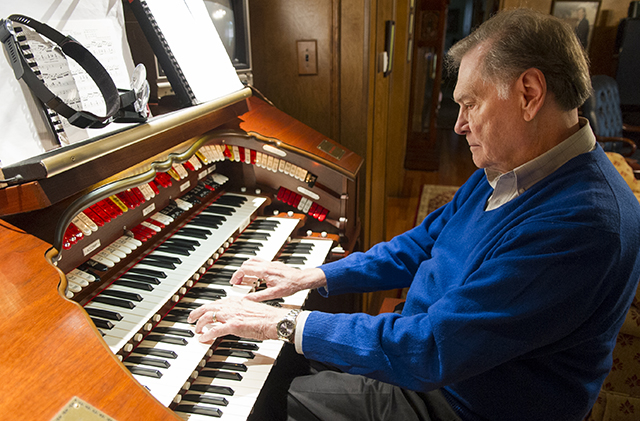 Dr. Bill Hanson, '61, plays the theater organ in the living room of his living room, outfitted with speakers to ensure optimal acoustics.