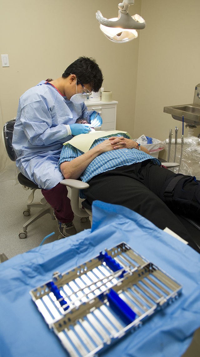 Fourth-year dental student Ethan Yang treats a patient at North Dallas Shared Ministries in June 2014.