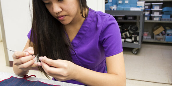 Fourth-year dental student Ticole Nguyen demonstrates the process for waxing a tooth.