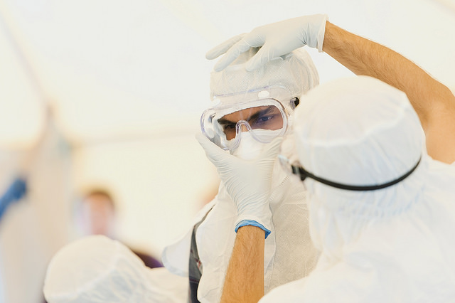 A man dresses in personall protective equipment