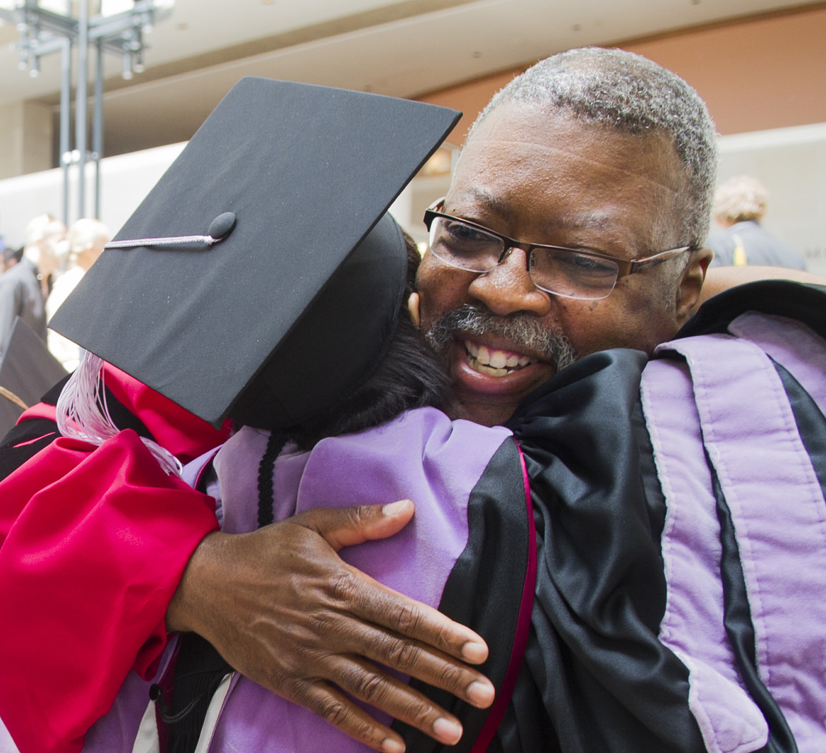 Dr. Reginald Taylor congratulates a student duriung commencement.