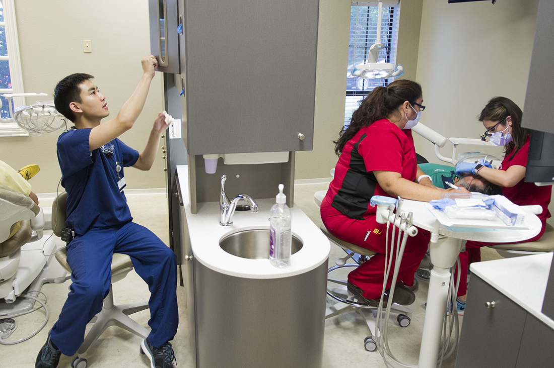 Dental students and assistants work in the dental bays at the Agape Clinic on June 25.