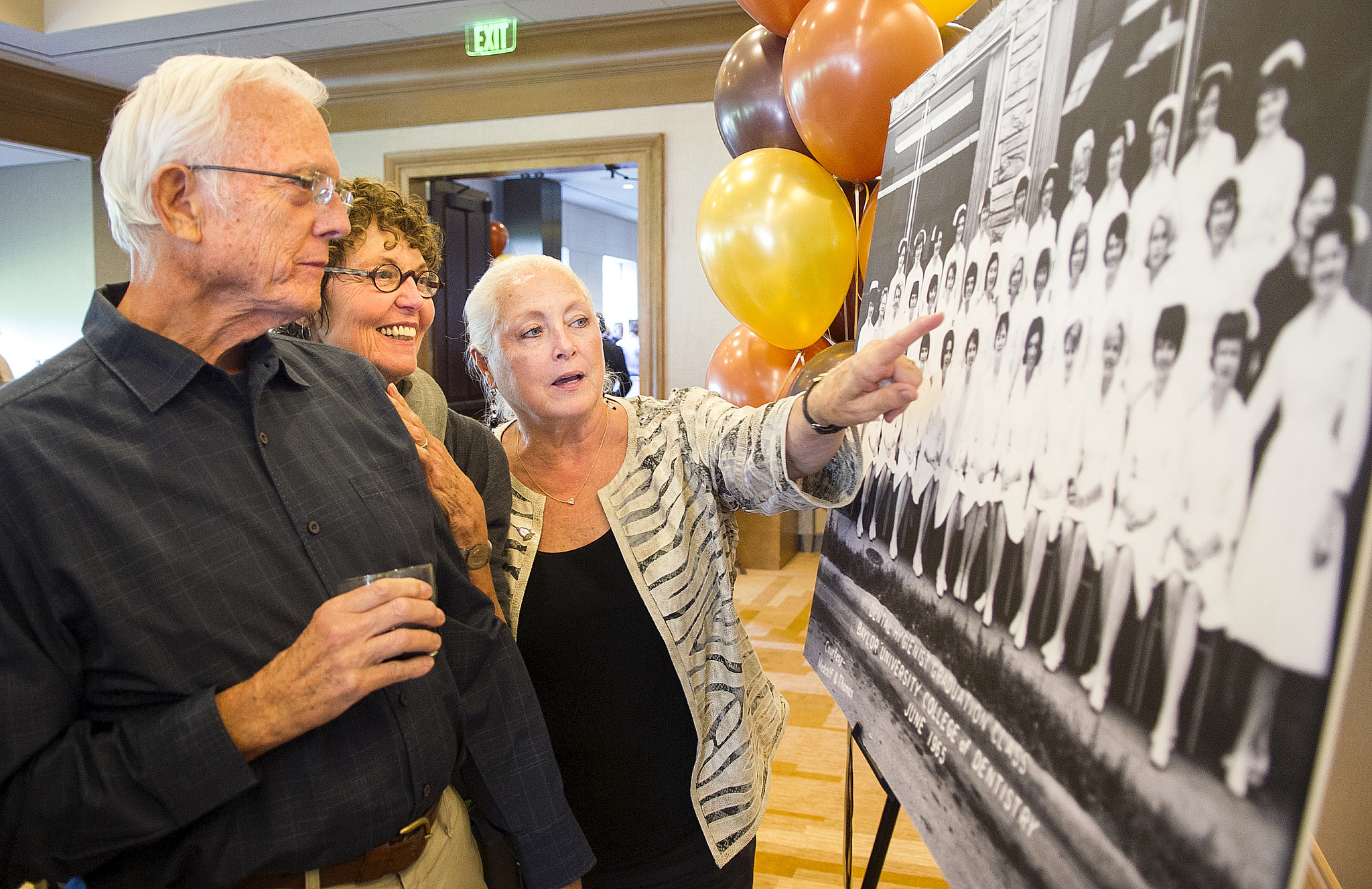 Dental hygiene alumni point out their photos during the 2015 reception at the Omni Hotel Dallas.