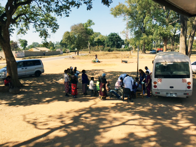 People line up outside the mobile dental unit to receive dental care.