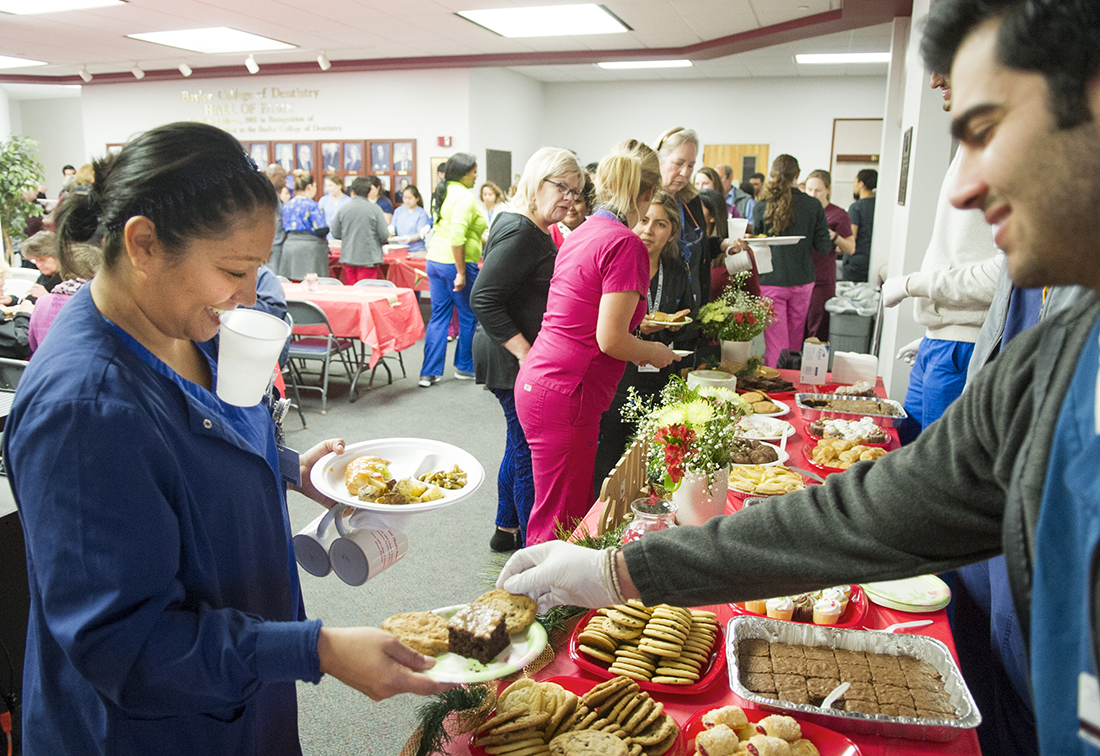 A Texas A&M College of Dentistry student serves a staff member dessert during the annual GRACE lunch event.