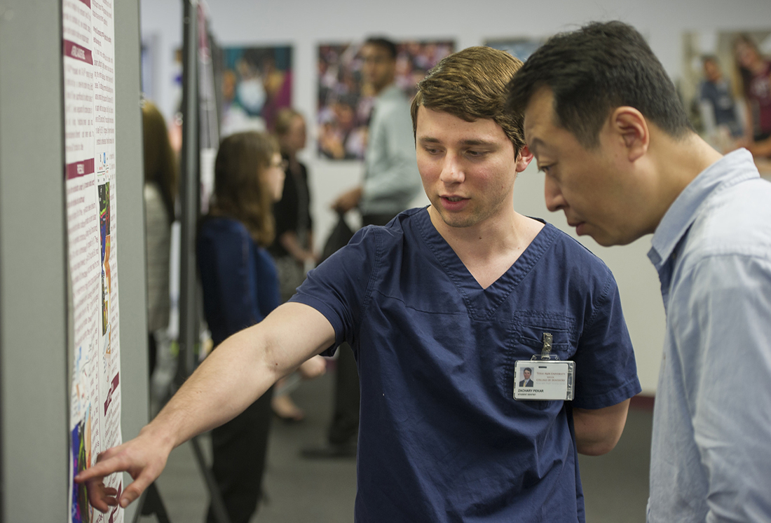 Pekar discusses his poster with Dr. Xiaofang Wang during the College of Dentistry's April 5 Research Scholars Day.