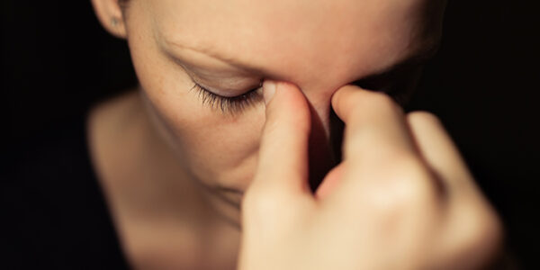 Woman holding her hand to her face