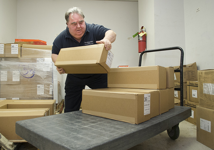 Marvin Vance loads a delivery cart in the college's storeroom.