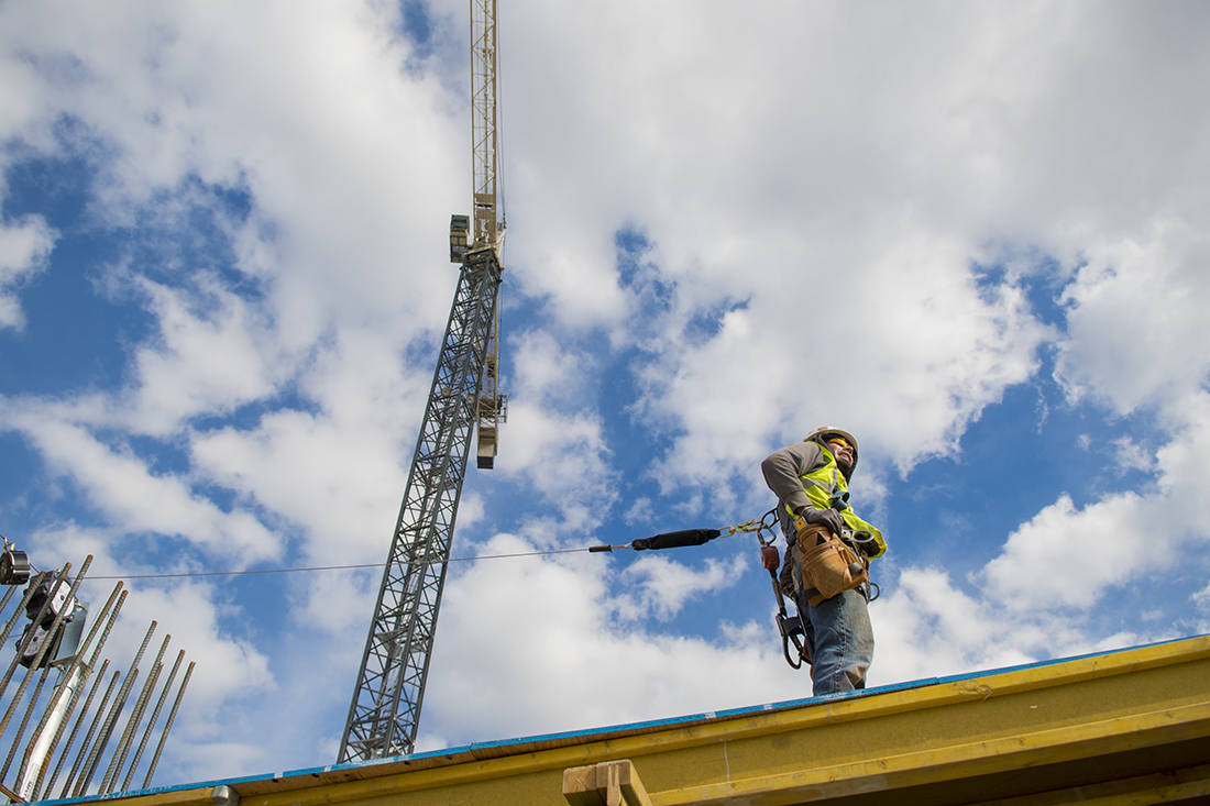 Construction worker pauses work above the second level of the new building in March 2018.