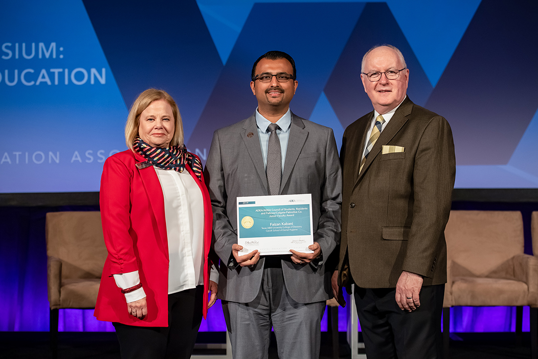 Dr. Faizan Kabani (center) accepts his award from Dr. R. Lamont MacNeil, the 2018-19 ADEA board chair (right), and Phyllis Martina with Colgate-Palmolive Co.