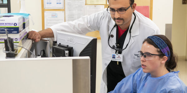 Dr Faizan Kabani with a student in the clinic