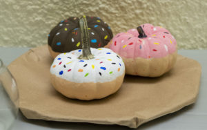 small pumpkins carved as sprinkled donuts