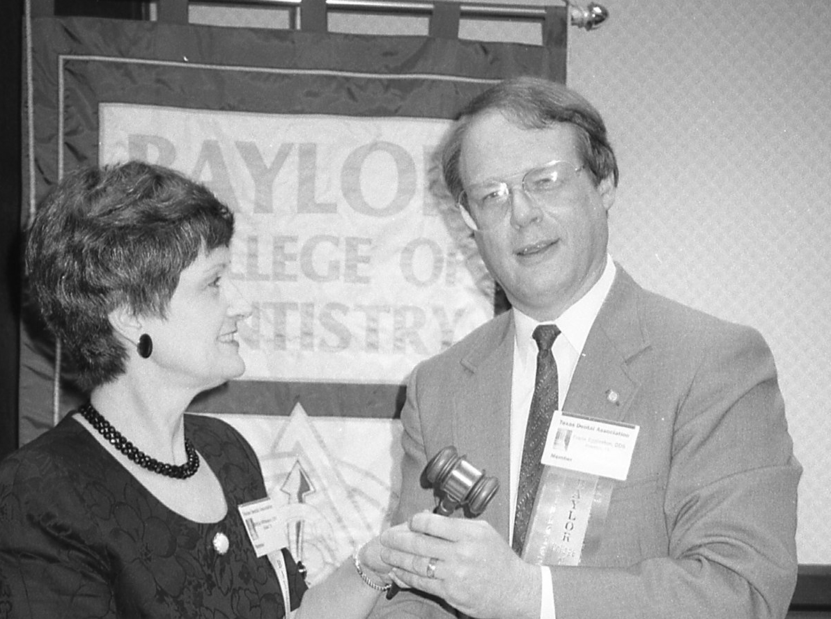 Incoming president Dr. Frank Eggleston accepts the gavel from outgoing president Dr. Bettye Whiteaker at the college's 1991 Alumni Association meeting.