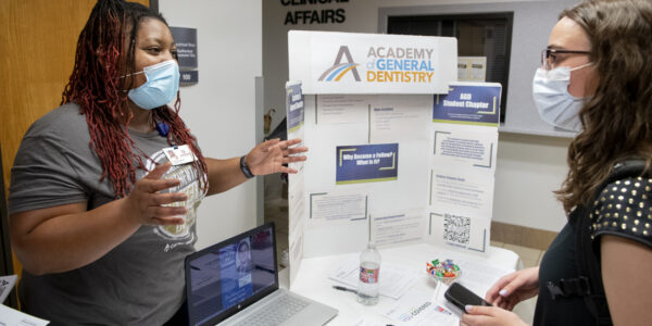 Fourth-year dental student Akeira “Cookie” Warner shares information with a new student during the student organization fair.