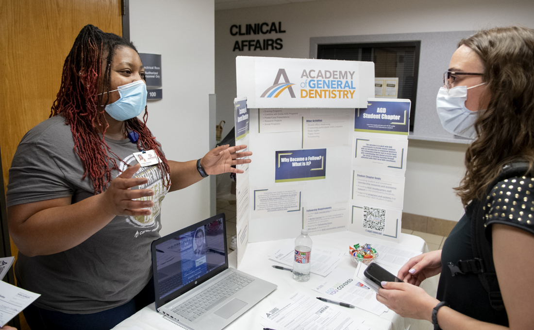Fourth-year dental student Akeira “Cookie” Warner shares information with a new student during the student organization fair.